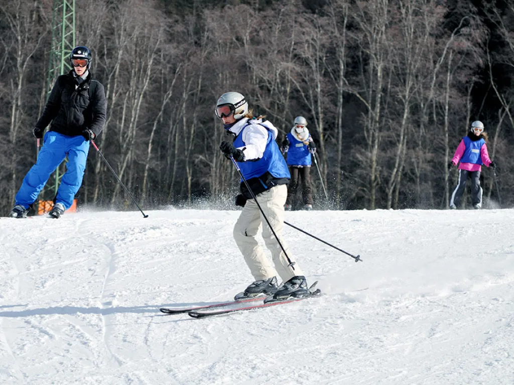 Skifahrende auf der Piste im Nachmittagslicht.